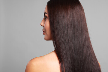Fototapeta premium Woman with beautiful smooth hair after lamination procedure on light grey background, back view. Space for text