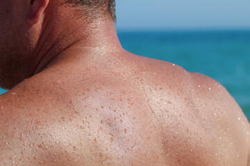 Naklejka premium Wet male shoulder close-up after swimming in sea