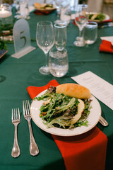 Elegant dining setup featuring a fresh salad and bread on a beautifully arranged table in a formal setting