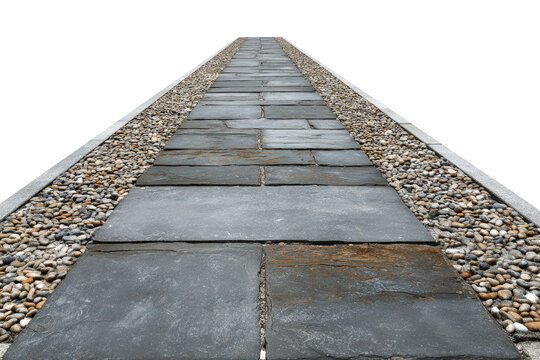 A long straight garden path made of dark stone slabs.