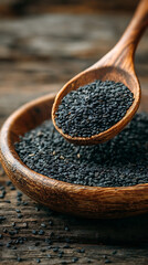 Wooden spoon filled with black sesame seeds over a wooden bowl graphic design
