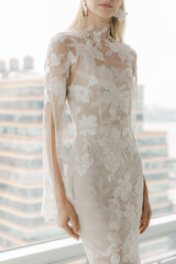 Elegant bridal gown with floral design displayed in a modern urban setting during daytime