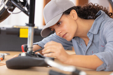 woman bicycle engineer is repairing a bike in the workshop