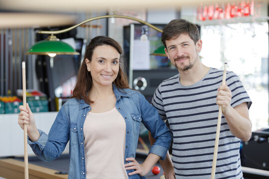 happy friends enjoying playing pool - Powered by Adobe