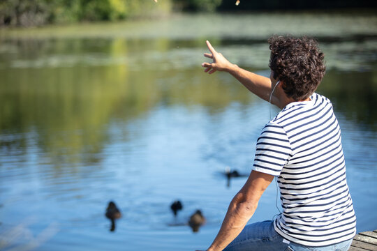 handsom young man is feeding ducks