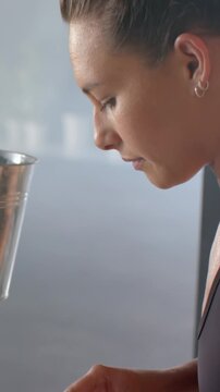 Vertical video: Woman reaching into bucket pulling soap and rubbing it, making lather for washing