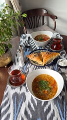 vegetable soup with bread Three golden brown samsa pastries with sesame seeds arranged in a pile...