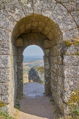 Fototapeta premium Ancient stone arch with view of landscape and mountains in Monsanto, Portugal.