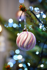 Obraz premium A Christmas decoration in the shape of a ball hanging on a branch of a Christmas tree