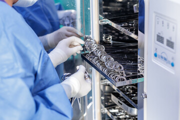 Technician loading surgical tools into autoclave for hospital sterilization