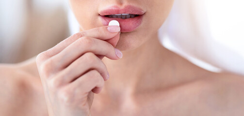 Fototapeta premium Body, beauty and health care, vitamins, birth control, pain relievers, antidepressants and home treatment during covid. Millennial woman in towel takes pill in morning, close up, cropped, copy space