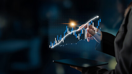 A business professional engaged in data analysis using a digital tablet, showcasing upward financial trends represented by a graphical interface, symbolizing success. Impute