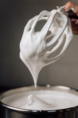 Whipped marshmallow cream pulled from mixer, close-up of airy texture and sweet dessert base