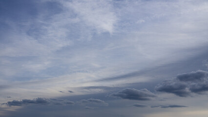 Dramatic cloudy sky with layered formations and soft gradients. Blue-gray tones create a moody, weather-driven atmosphere.