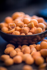 Peanuts in a crispy crust on black table.