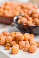 Peanuts in a crispy crust on white table.