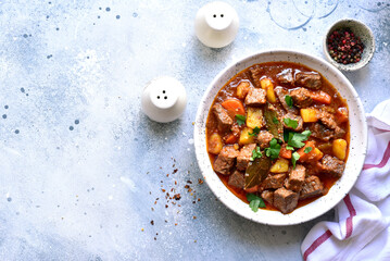 Goulash (meat stew with tomatoes and paprika) - traditional dish of hungarian cuisine .Top view with copy space.