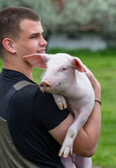 Happy male farmer holding his pet pig close © Budimir Jevtic