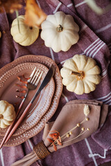 A beautifully arranged Thanksgiving table featuring white pumpkins, pink plates, and earthy napkins. Ideal for fall gatherings, seasonal invitations, and cozy home decor