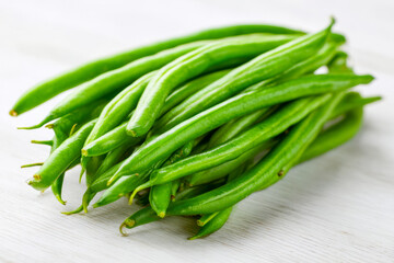 Fototapeta premium Fresh green beans on a light surface