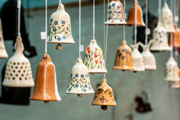 Colorful handmade ceramic bells hanging on display at a market or craft fair in Vilnius, Lithuania, Europe