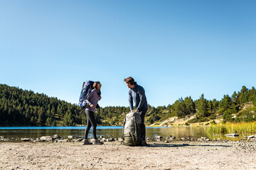 Hiking friends adjusting backpacks with determination and teamwork spirit
