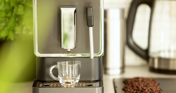 Close-up of the making of a double espresso in a transparent glass cup made in a home coffee maker. Strong black coffee with golden crema, ideal for caf&eacute;, breakfast, or lifestyle concept