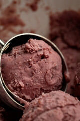 Creamy raspberry ice cream scoops in close-up, rich texture and vibrant pink color