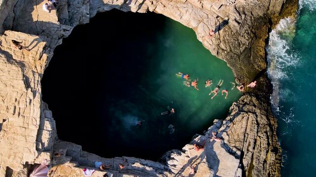 People swimming in Giola lagoon in Thassos Island, Greece. One of the most place in Thassos. Amazing sea with clear blue water. Aerial panoramic drone view from above, top view from drone. Summer holi