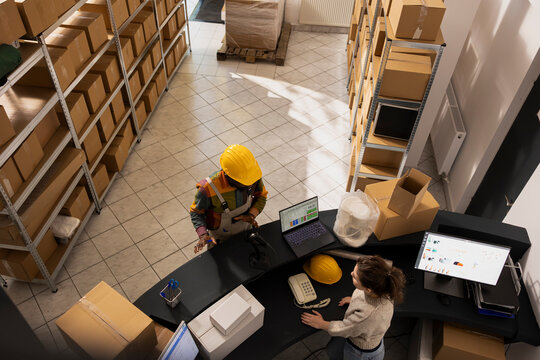 Diverse employees team managing storage inventory and preparing orders for dispatch, ensuring parcels are packaged correctly for shipment and supporting small delivery services for e-business. - Powered by Adobe