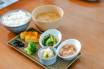 Traditional Japanese breakfast with rice, miso soup, natto and side dishes