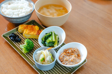 Traditional Japanese breakfast with rice, miso soup, natto and side dishes