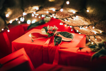 Red wrapped gifts with rose and string lights in background, evoking celebration, romance, and...