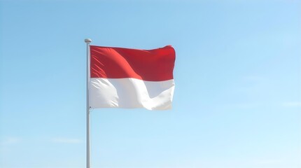Vibrant Indonesian flag, the iconic red and white national symbol, proudly waves on a flagpole against a clear blue sky, embodying Indonesian patriotism and freedom.