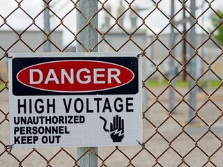High Voltage danger warning sign on chainlink fence