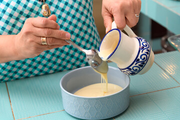 Woman preparing syrup with condensed milk for a Christmas apple salad