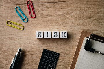 There is wood cube with the word RISK. It is as an eye-catching image.