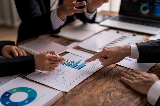 Business people analyzing financial chart at office desk