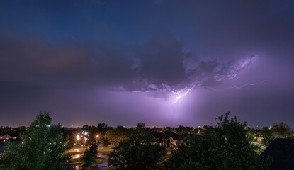 Panoramic view of a dramatic thunderstorm over a suburban landscape at night