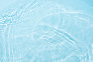 Blue water with ripples on the surface. Defocus blurred transparent blue colored clear calm water surface texture with splashes and bubbles. Water waves with shining pattern texture background.