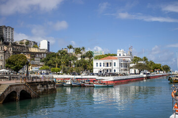 Obraz premium Salvador, Bahia, Brasil Brazil Historic colonial building by the waterfront under a blue sky in a tropical coastal town. Traditional architecture with white walls, red tiled roof, palm trees