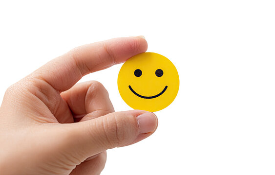 A child's hand holds a small, yellow smiley face sticker