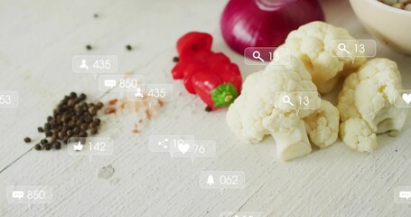 Showing cauliflower florets, pepper and onion slices, translucent social icons on table, copy space