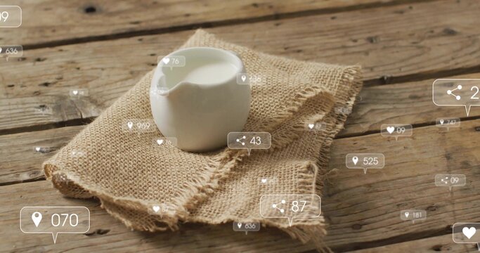 Showing white ceramic milk pitcher on frayed burlap atop rustic table floating social media metrics