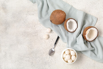 Coconuts and bowl with white chocolate candies on light table