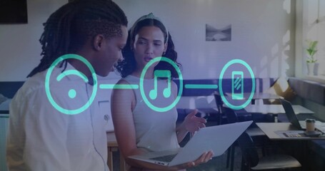 Professionals gesturing at laptop, discussing audio controls in modern office, with neon teal icons