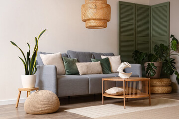 Interior of modern living room with grey sofa, green folding screen and coffee table