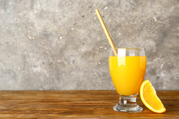 Glass of fresh orange juice on wooden table