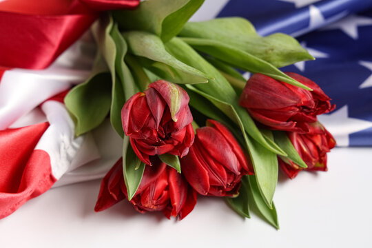 Beautiful tulip flowers and flag of USA on light background, closeup. Memorial Day celebration