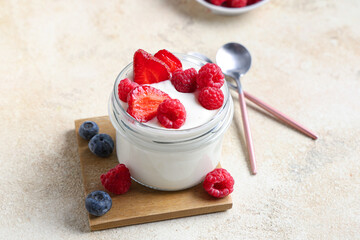 Jar of tasty yogurt with different fresh berries on white background